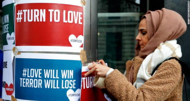 A woman hangs posters supporting the Muslim community in Southern California (Credit: CNN)