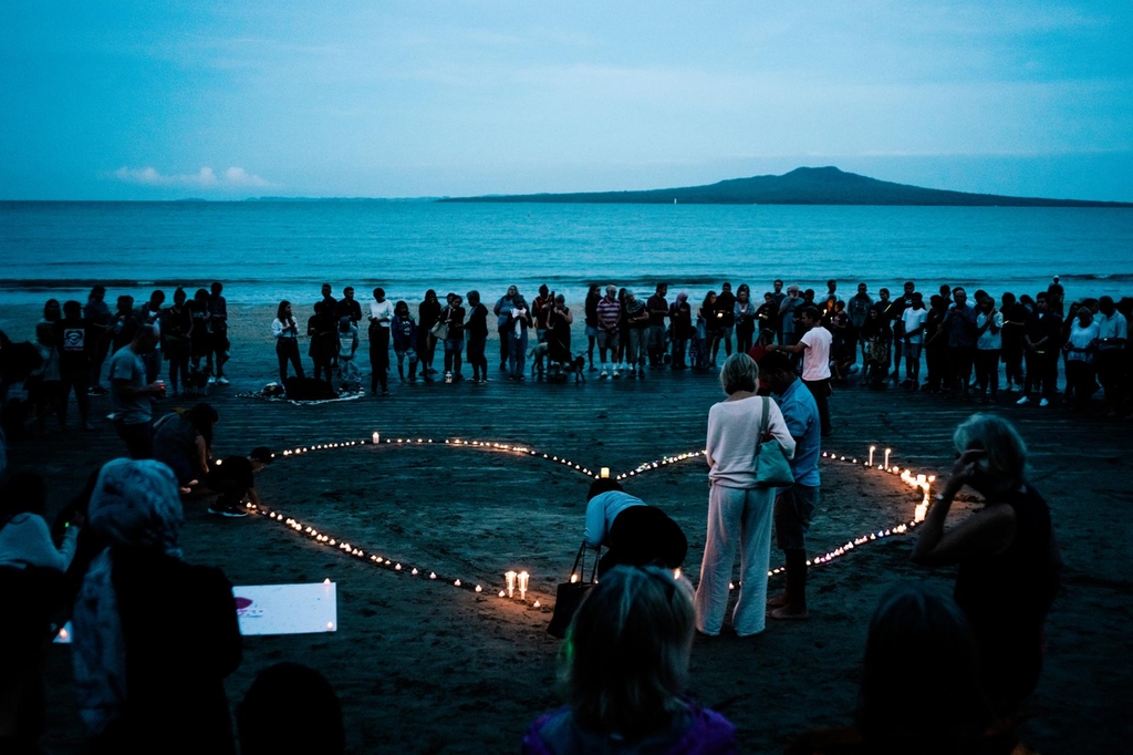 Crowds gather for a vigil on Takapuna beach Auckland. Getty Images