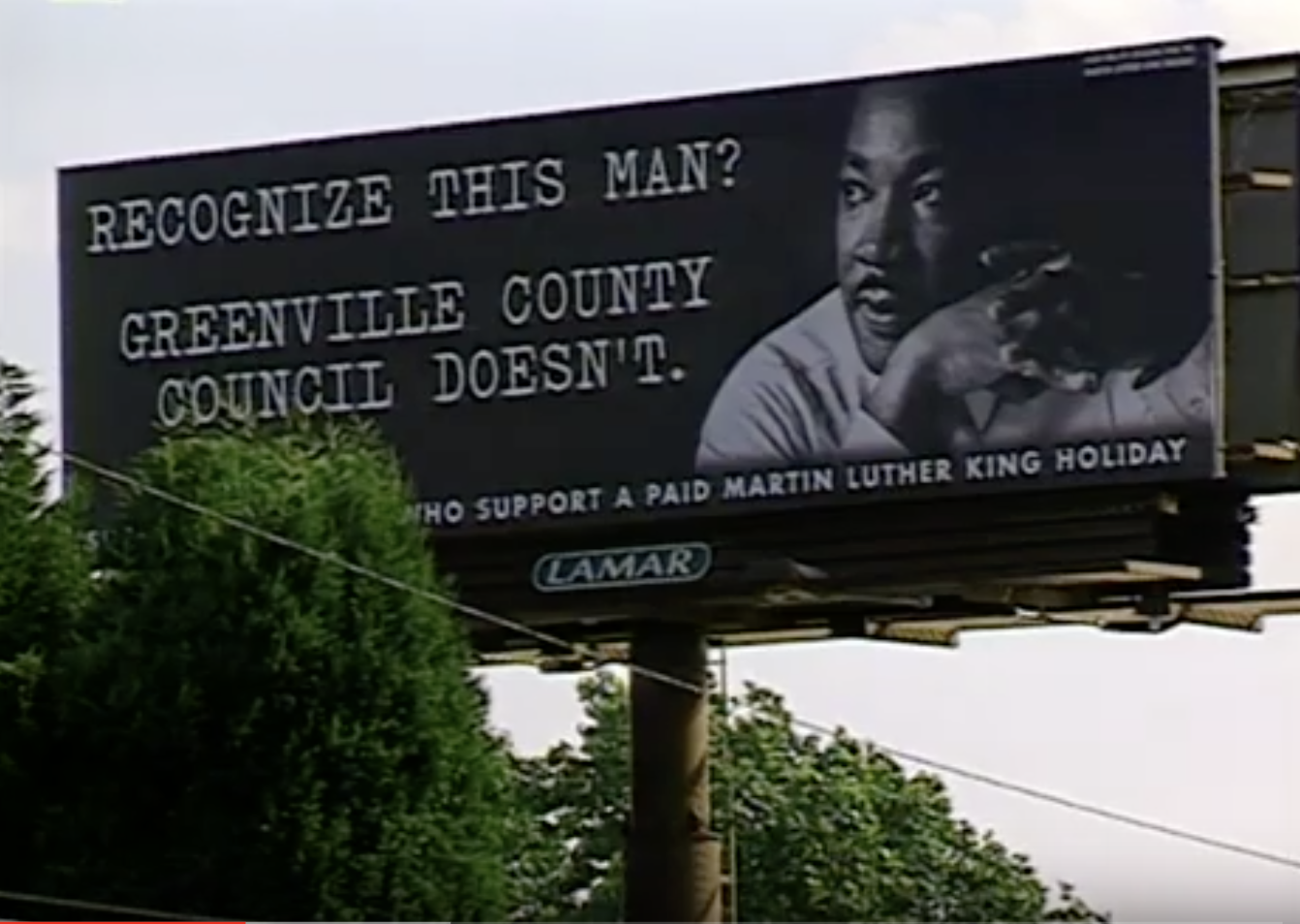 A sign by the side of the road paid for by community members who supported a Martin Luther King Jr. Holiday in Greenville County. (Credit: NIOT 'Holiday' film, 2003)