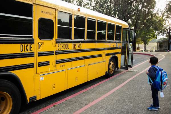 A boy boards a Dixie School District school bus in Marin County, CA (SF Chronicle)