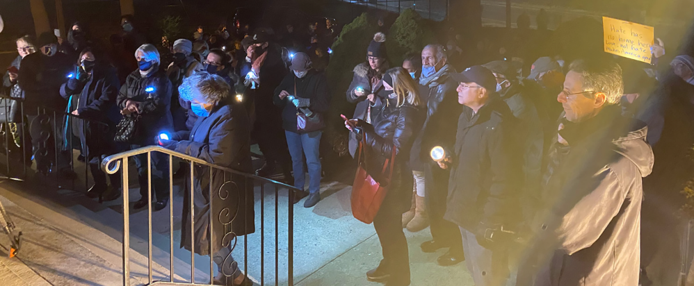 The crowd assembled in front of Central Synagogue-Beth Emeth, on Demott Avenue, on Dec. 1 with flashlights to illuminate the “darkness” they said they had witnessed the week before. (TOM CARROZZA/HERALD)