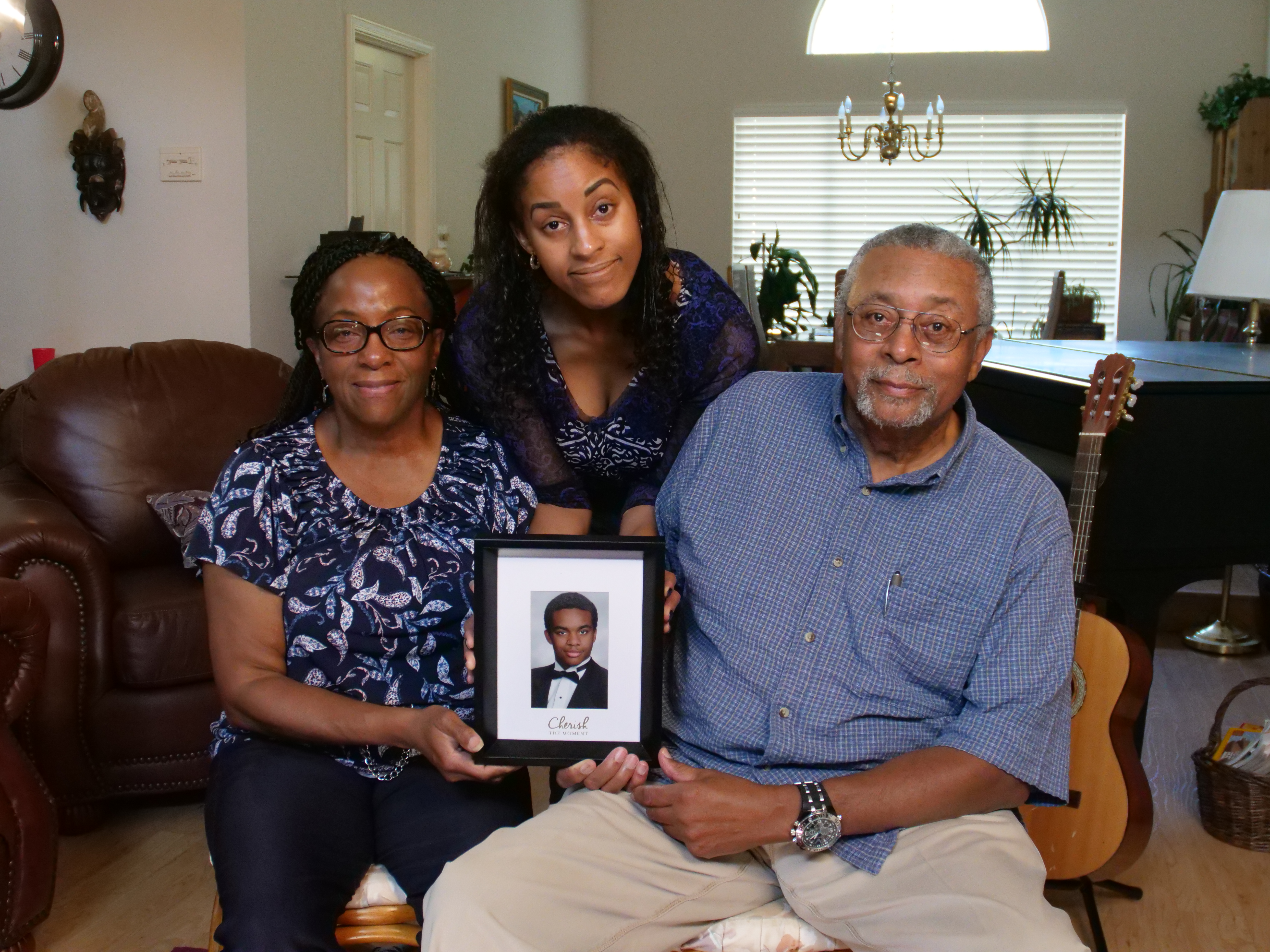 Bill, Renee and Stacey Sims with a picture of Will Sims