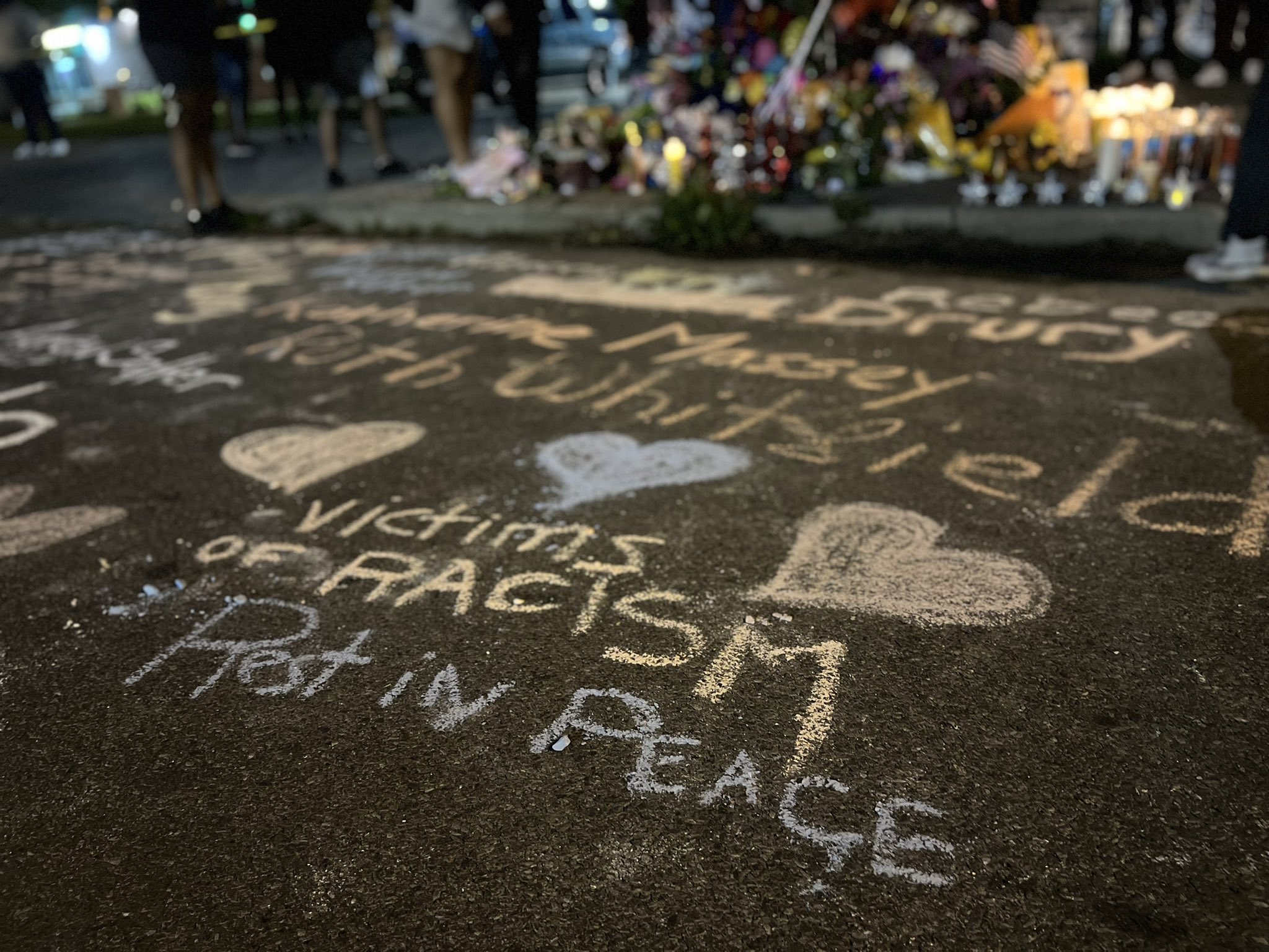 The names of the 10 victims killed at the Buffalo supermarket are written on the street in chalk. It’s part of a growing memorial created by family, friends, and total strangers. (Credit: Twitter)